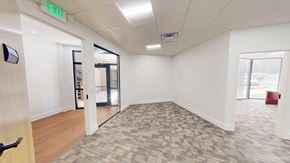 Atlanta apartment for rent - A room with a carpeted floor and a green exit sign on the wall.