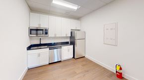 Atlanta apartment for rent - A kitchen with white cabinets and a black countertop.