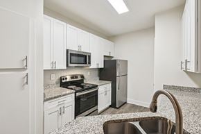 Atlanta apartment for rent - A renovated kitchen with white cabinets, granite countertops through out and stainless steel appliances
