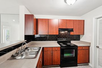 Lawrenceville apartment for rent - A kitchen with a black oven and brown cabinets.