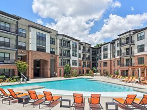 Atlanta apartment for rent - A swimming pool surrounded by orange chairs in front of apartment buildings.