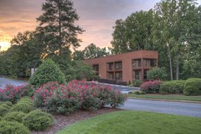 Atlanta apartment for rent - A building with the word "AVILK" on it is surrounded by greenery and flowers.