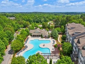 Newnan apartment for rent - A large swimming pool surrounded by trees and resident clubhouse