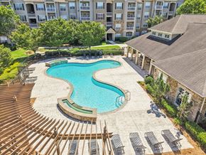 Stonecrest apartment for rent - A large swimming pool surrounded by a wooden deck and lounge chairs.