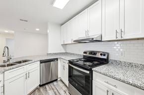 Lawrenceville apartment for rent - A kitchen with stainless steel appliances, white cabinets and a granite countertop.