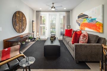 Atlanta apartment for rent - A living room with a grey couch, a black coffee table, and a large painting on the wall.