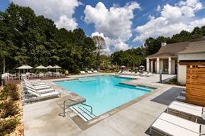 Norcross apartment for rent - A large swimming pool surrounded by sun loungers and umbrellas.