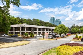 Atlanta apartment for rent - A parking lot with cars and a building in the background.