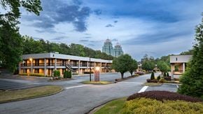 Atlanta apartment for rent - A large building with a parking lot in front of it. office spaces in sandy springs, brookhaven, and buckhead