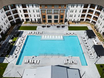 Douglasville apartment for rent - A large swimming pool surrounded by apartment buildings.