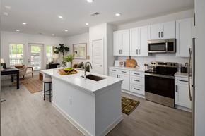 Douglasville apartment for rent - kitchen with quartz countertops, stainless steel appliances, dedicated eat-in island, with a dishwasher, microwave, oven, glass top stove, garbage disposal, and slow close cabinets & drawers