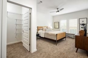 Locust Grove apartment for rent - A large bedroom with a bed, dresser, and a ceiling fan.