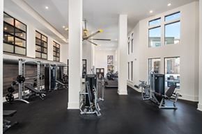 Atlanta apartment for rent - A gym with a variety of equipment and a large mirror on the wall.