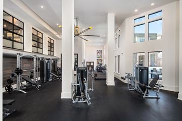 Atlanta apartment for rent - A gym with a variety of equipment and a large mirror on the wall.