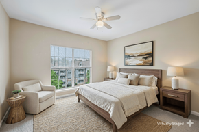 Newnan apartment for rent - A bedroom with a large bed, a chair, and a painting on the wall.