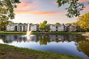 Lawrenceville apartment for rent - A serene pond surrounded by residential buildings with a fountain in the middle.