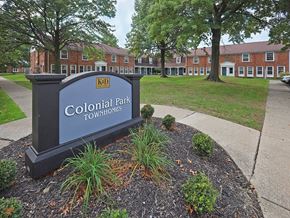 Euclid apartment for rent - A sign that says Colonial Park Townhomes in front of some buildings.