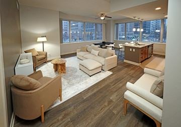 Cleveland apartment for rent - A living room with a white couch and brown chairs.