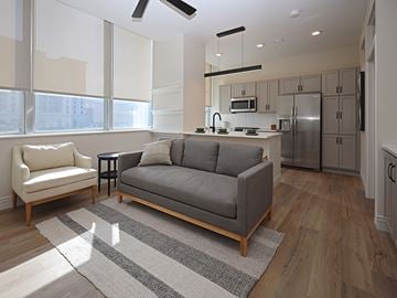 Cleveland apartment for rent - A modern living room with a grey sofa and a white chair.