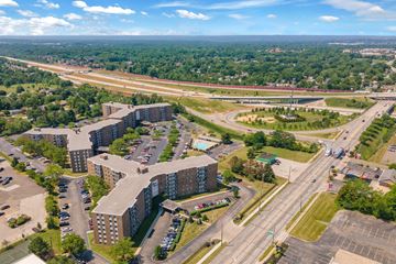 Bedford Heights apartment for rent - A large building complex is surrounded by a parking lot and a highway.