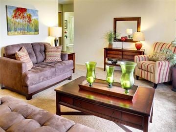 Bedford Heights apartment for rent - a living room with couches and a table with green vases