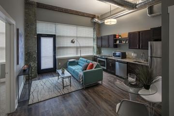 Grand Rapids apartment for rent - a living room and kitchen with a blue couch and a table