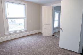 Rapids townhouse for rent - A room with a carpeted floor, a window, and a door.