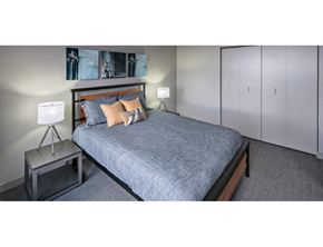 Grand Rapids apartment for rent - A bedroom with a bed, a nightstand, and a lamp.