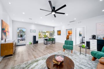 Vista apartment for rent - A modern living room with a wooden coffee table and green chairs.