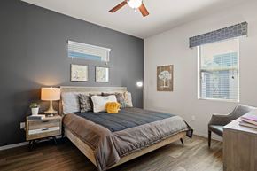 Chandler apartment for rent - A bedroom with a bed, nightstand, chair, and pictures on the wall.