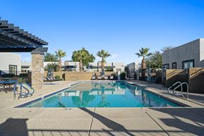 Chandler apartment for rent - A swimming pool with a slide and palm trees in the background.