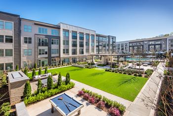 Landscaped outdoor space with fireplace, smart tv, grilling stations, outdoor dining, ping pong and bag toss
