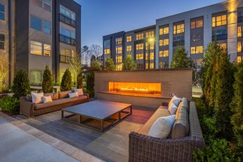 Landscaped outdoor space with fireplace, smart tv, grilling stations, outdoor dining, ping pong and bag toss