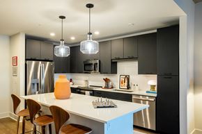 Raleigh apartment for rent - a kitchen with a white island and black cabinets