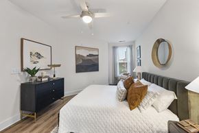 Raleigh apartment for rent - a bedroom with a large white bed and a ceiling fan