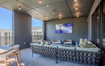Raleigh apartment for rent - A modern living room with a large sofa and a flat screen TV.