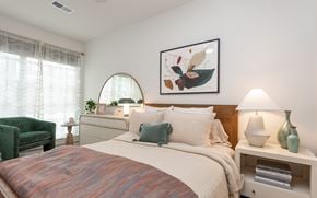 Raleigh apartment for rent - A bedroom with a large bed and a green chair.