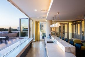 Raleigh apartment for rent - A modern kitchen with a long counter and a view of the city.