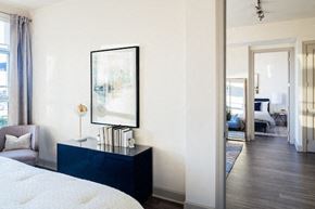 Raleigh apartment for rent - A bedroom with a large bed and a painting on the wall.