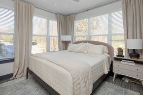 Raleigh apartment for rent - a bedroom with a bed and three windows