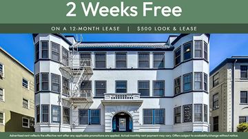 Oakland apartment for rent - A white and black building with a sign offering 2 weeks free on a 12-month lease.