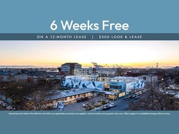 Oakland apartment for rent - A large building with a sign offering 6 weeks free on a 12-month lease.