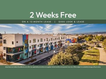 Oakland apartment for rent - A building complex with a sign offering 2 weeks free on a 12-month lease.