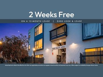 Oakland apartment for rent - A building with a sign offering a 2 weeks free on a 12-month lease.