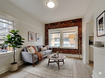 Oakland apartment for rent - A living room with a grey couch and a brown coffee table.