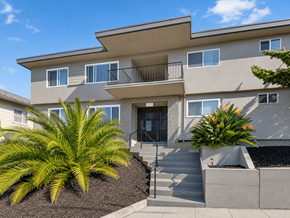 Oakland apartment for rent - A modern two-story house with a balcony and a front yard with plants.