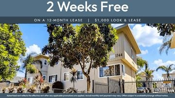 Oakland apartment for rent - A house with a sign offering 2 weeks free on a 12-month lease.