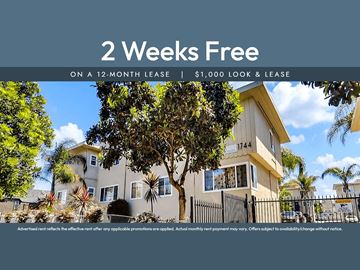 Oakland apartment for rent - A house with a sign offering 2 weeks free on a 12-month lease.