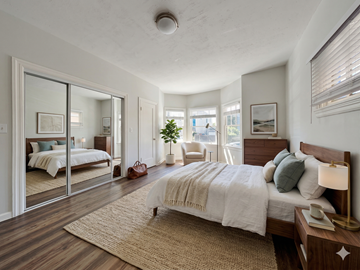 Oakland apartment for rent - A bedroom with a large bed and a mirror on the wall.