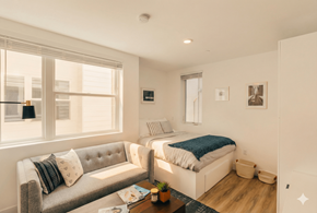 Oakland apartment for rent - A well-lit bedroom with a bed, couch, and window.